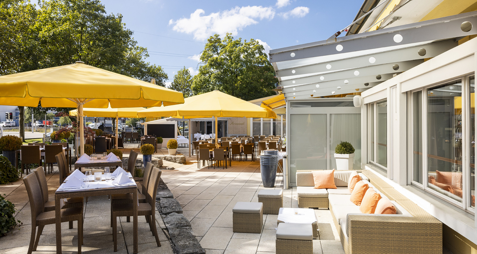 Terrasse mit Tischen, Stühlen und Sonnenschirmen des Sorell Hotels Sonnental