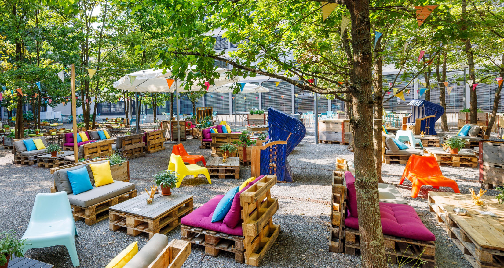 Lounges, Tische und farbenfrohe Kissen im Pünt Sommergarten