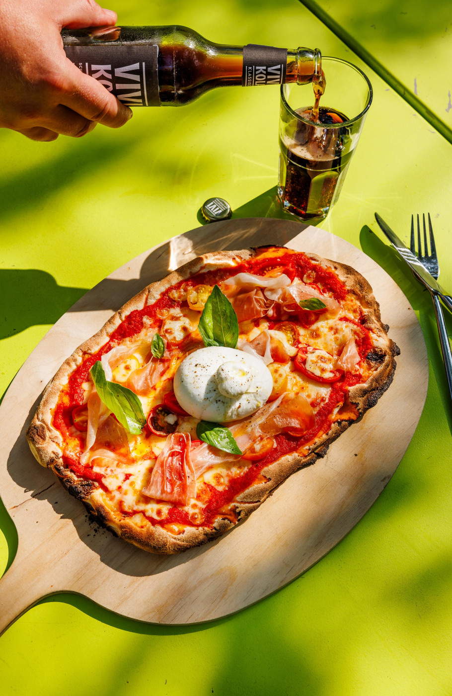 Pizza und Kola auf einem der Tische im Pünt Sommergarten