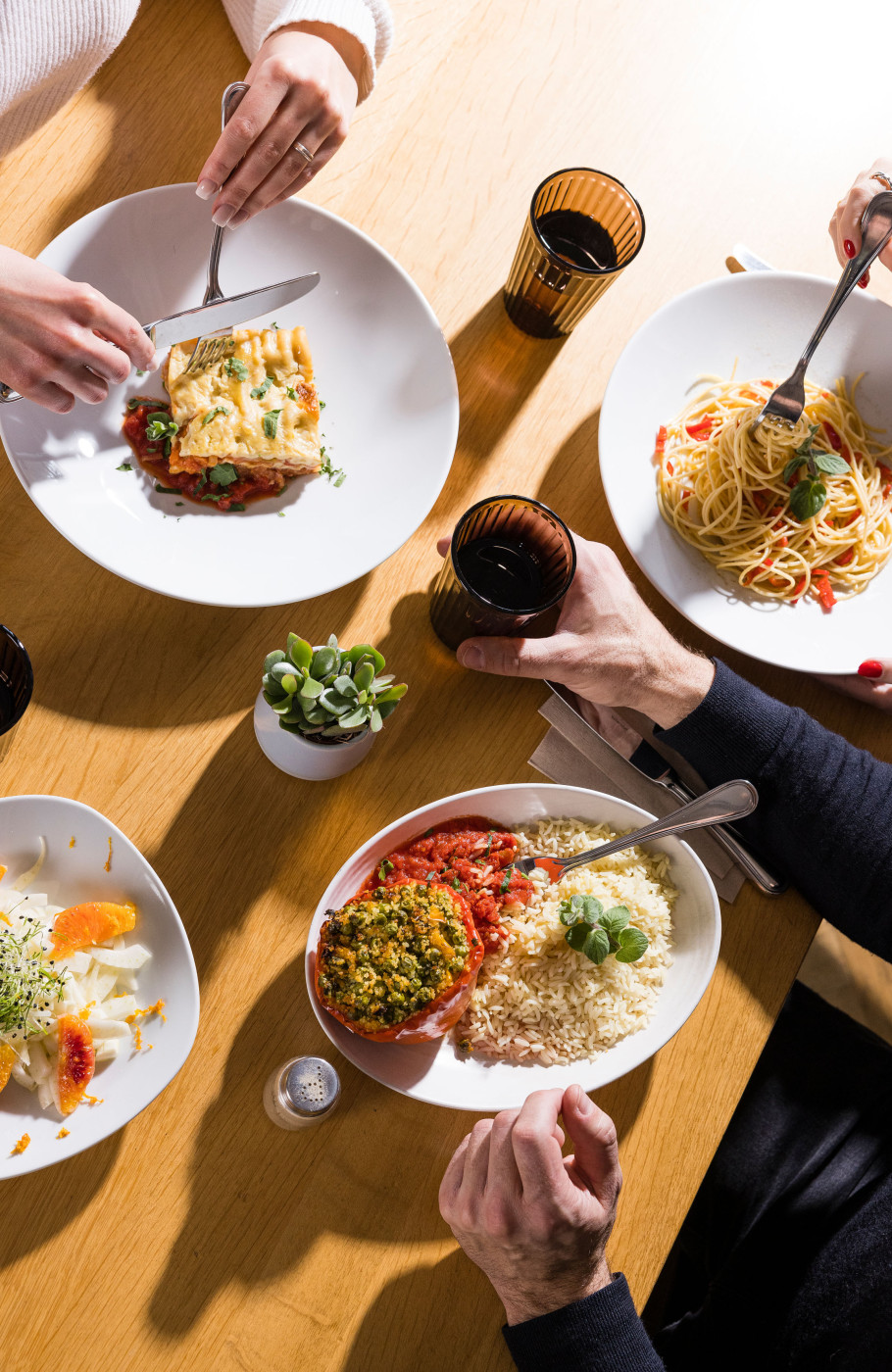Tisch mit drei Personen und verschiedene Speisen