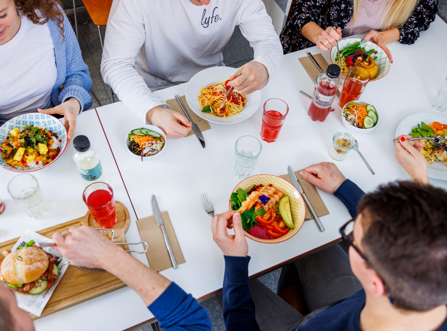 Tisch mit verschiedenen Essen und sechs Personen