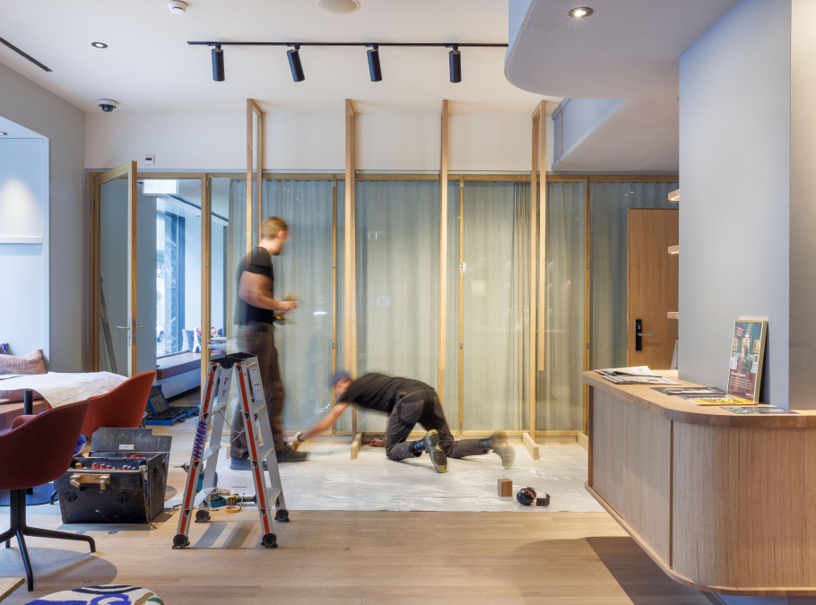 Zwei Männer arbeiten an einem Regal aus Holz in einer Hotellobby