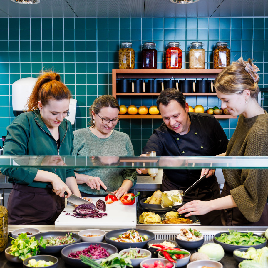 Team in einer Küche bereitet gemeinsam Essen zu