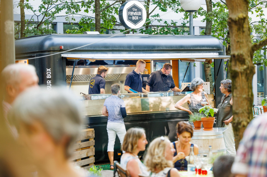 Gäste stehen beim Foodtruck im Pünt Sommergarten an