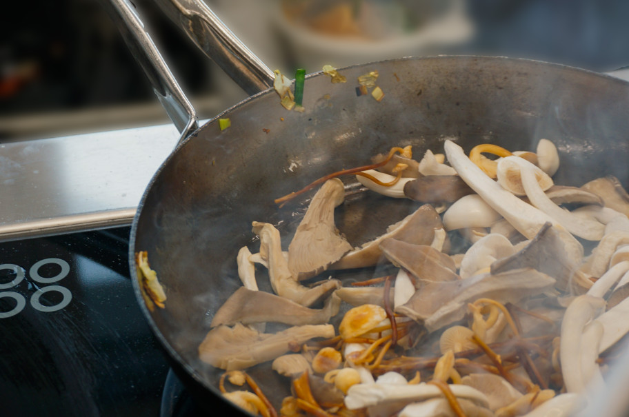 Pfanne auf dem Herd mit verschiedenen Pilzen beim Anbraten