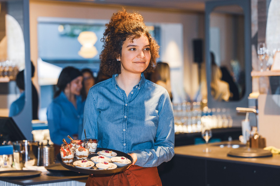 Servicefachangestellte mit einem Tableau voll essen