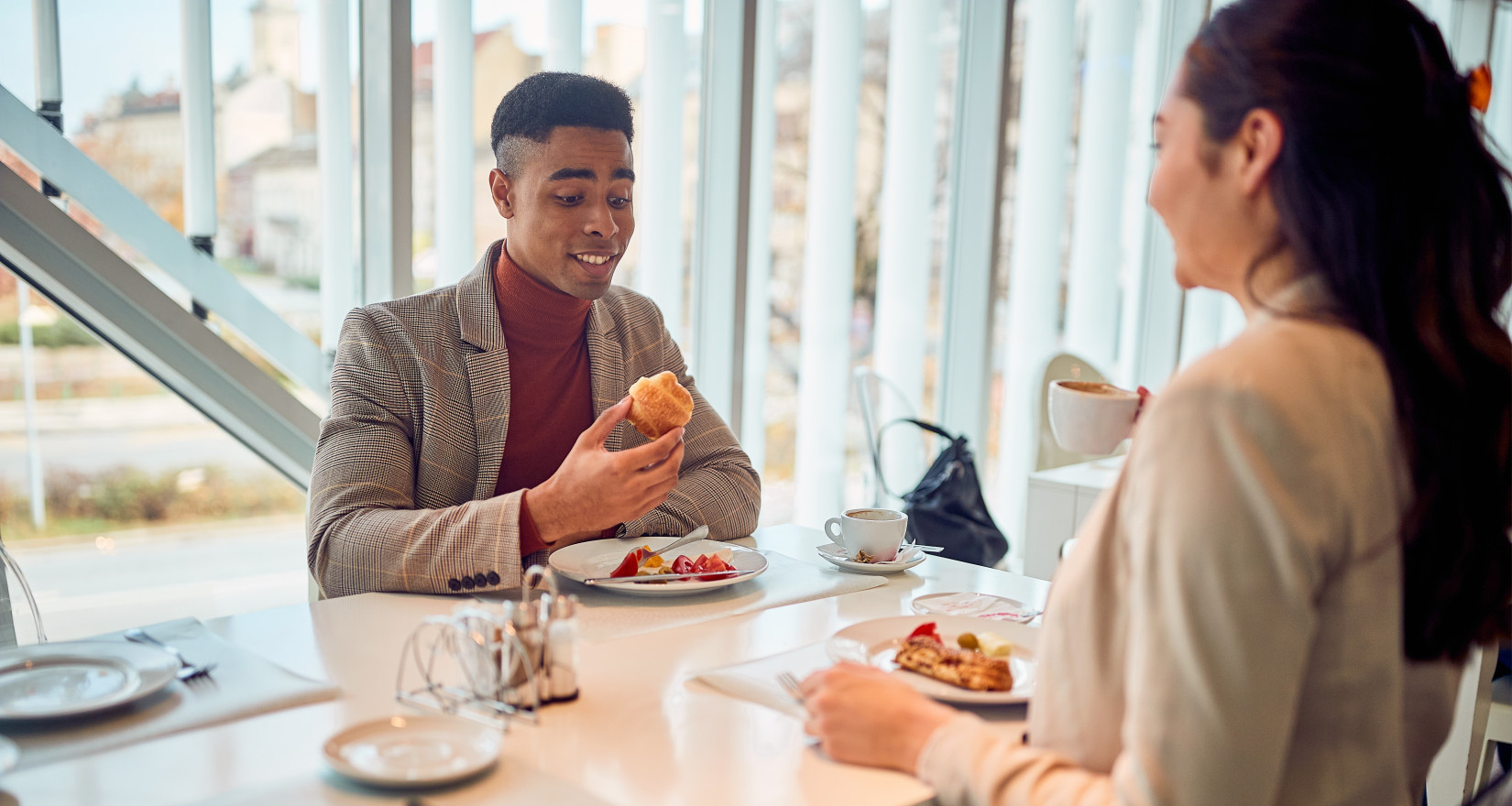 zwei Mitarbeitende essen ihr Mittagessen an einem Tisch