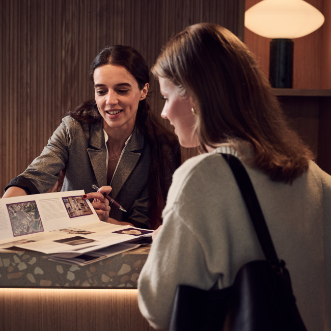 Frau beim Check-in an einer Hotelrezeption