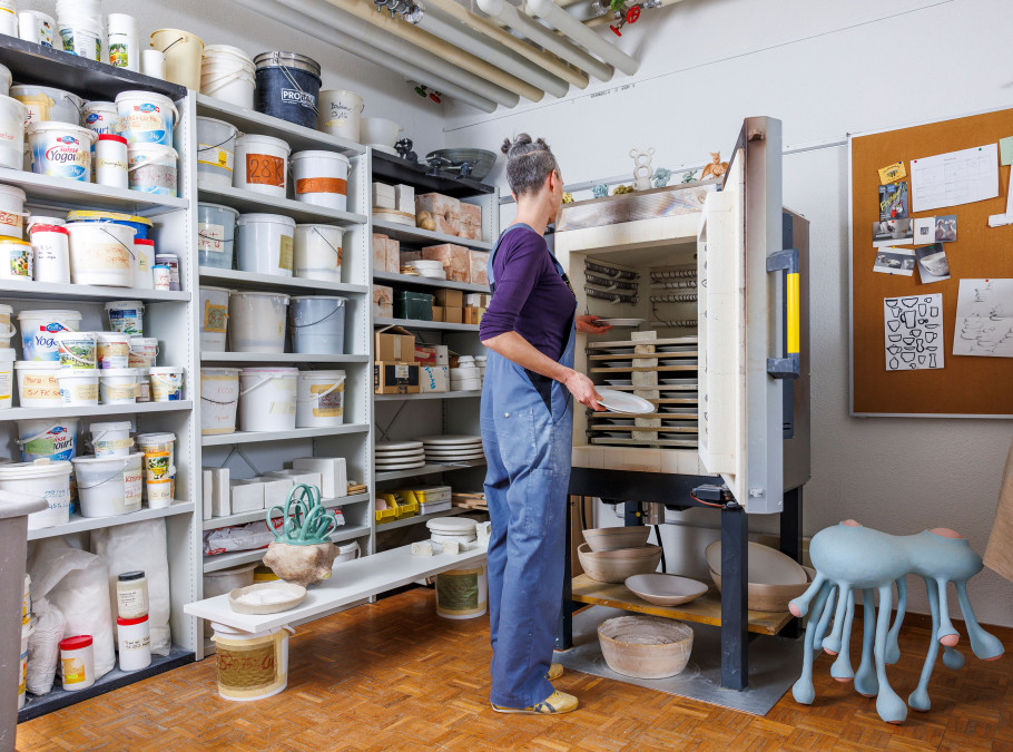 Frau in einem Keramikatelier baut den Brennofen zusammen